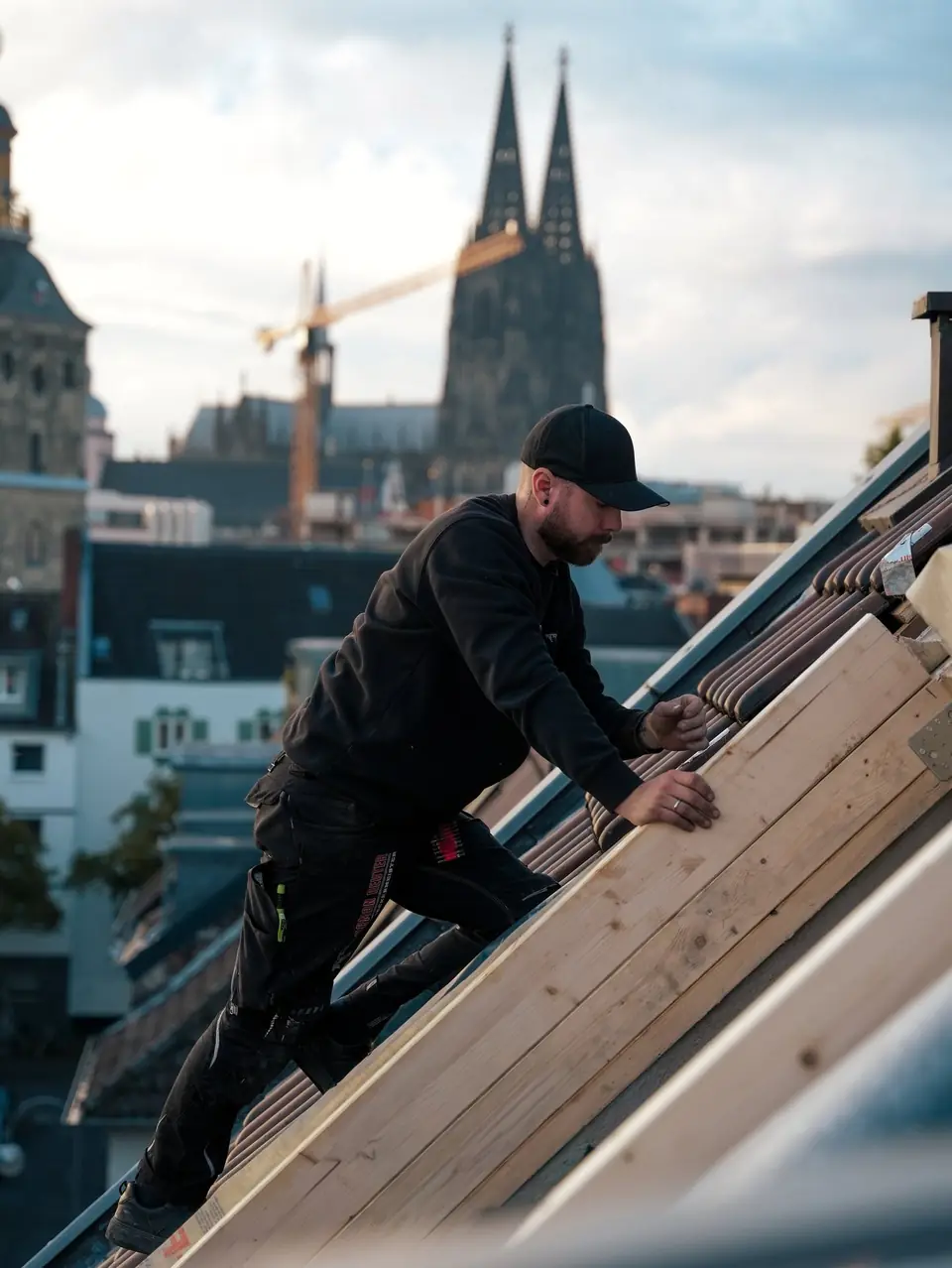 Dachdecker von Reuterdach beim Einbau an einer Gaube, im Hintergrund der Kölner Dom