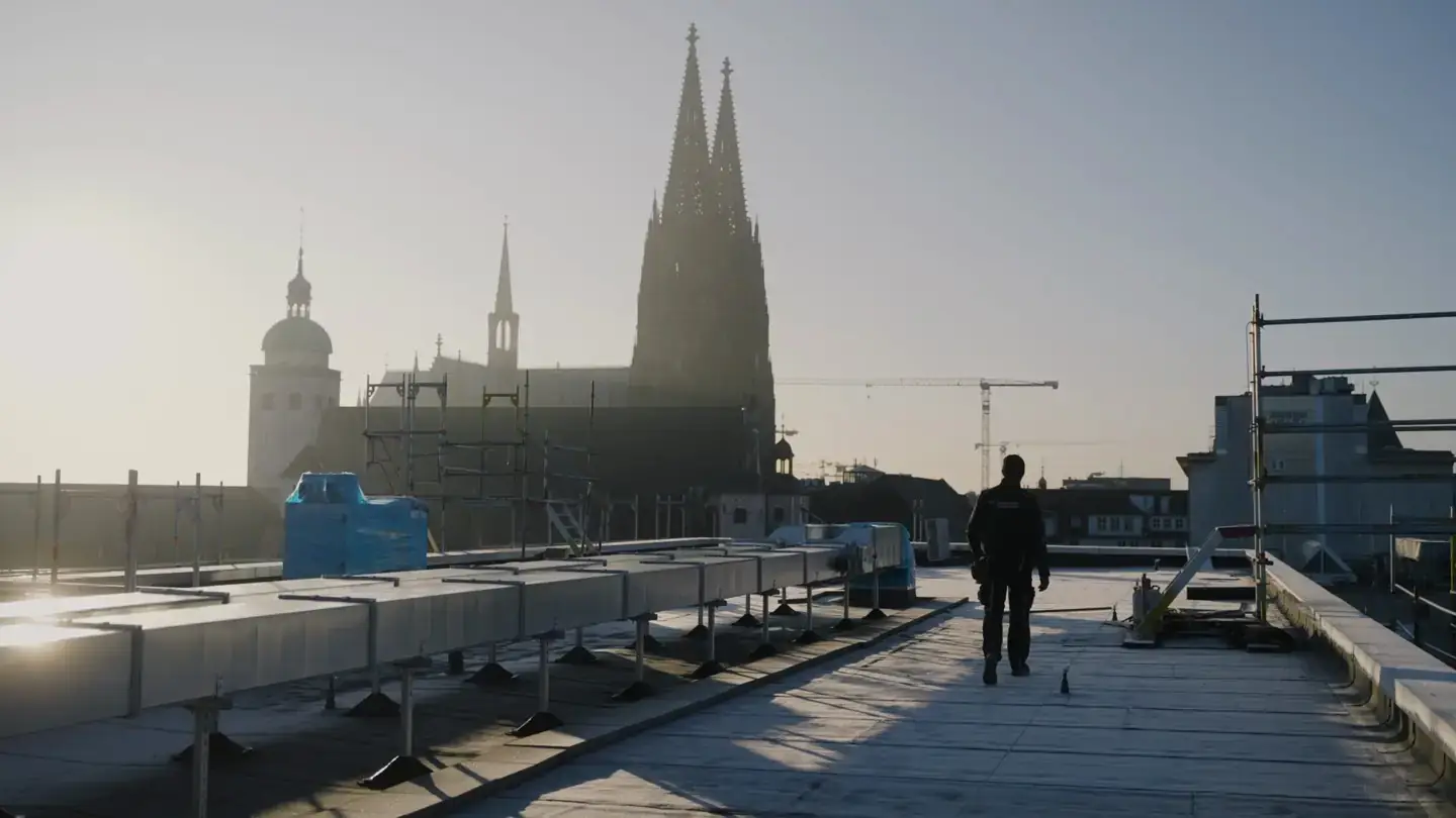 Dachdecker von Reuterdach auf einem Flachdach mit Blick auf den Kölner Dom